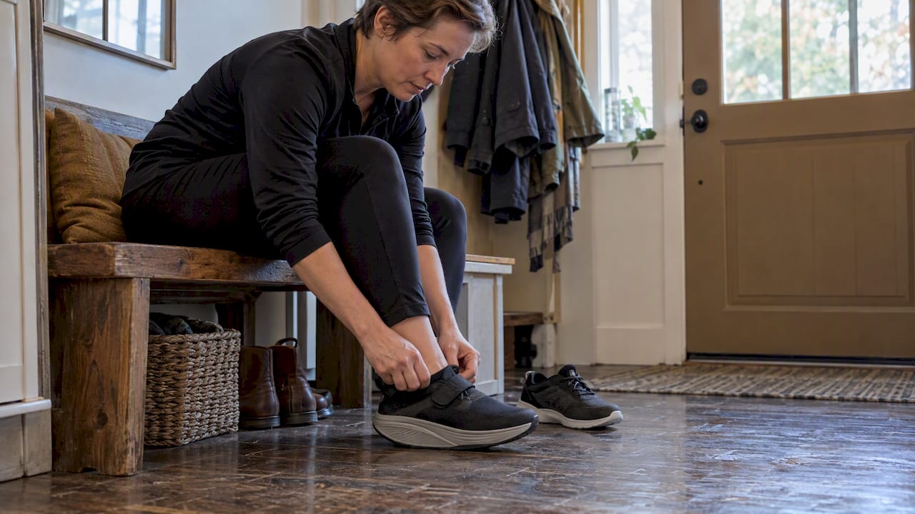 Person fastening a rocker-bottom walking shoe