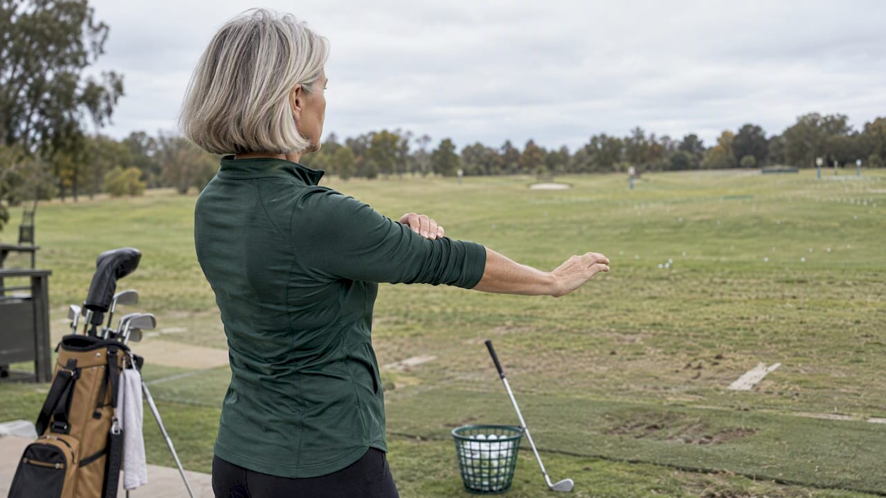 Golfer warming up forearms before a round